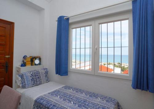 a bedroom with a window with a view of the beach at casa amor in Torrevieja