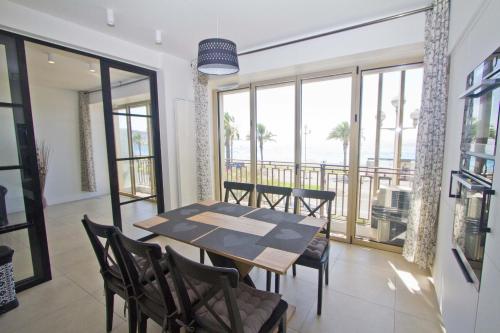 une salle à manger avec une table et des chaises et un balcon dans l'établissement Sea Front Palace Promenade, à Nice