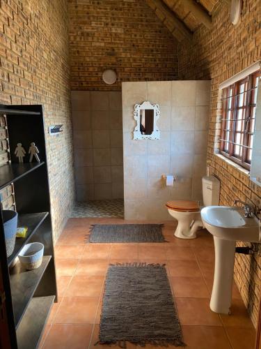 łazienka z toaletą i umywalką w obiekcie Soetgeluk Farm Cottage w mieście Hekpoort