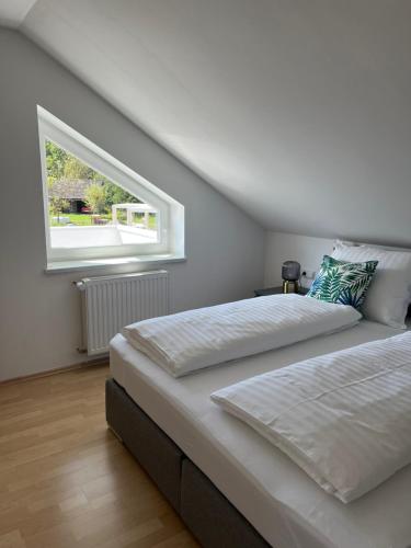 - une chambre avec 2 lits et une fenêtre dans l'établissement Das Bergl, à Rosegg