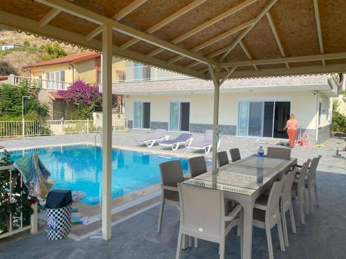 a patio with a table and chairs next to a pool at Villa Venus in Gazipasa
