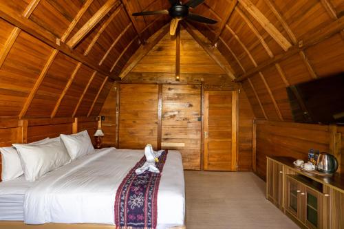 a bedroom with a bed and a ceiling fan at Tiing Bali Guest House Kintamani in Kintamani