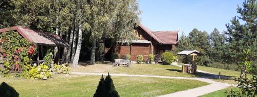 a house with a yard with a bench in front of it at Vila Mera in Pabradė