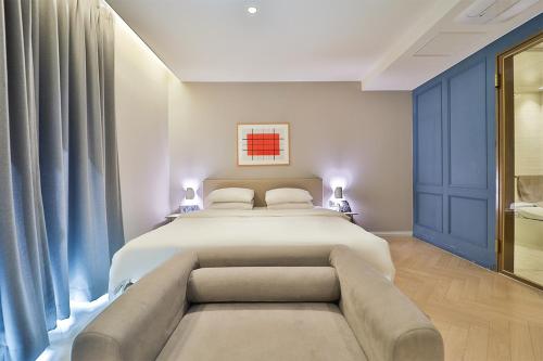 a bedroom with a large bed and a couch at Brown Dot Hotel Ulsan Samsan in Ulsan