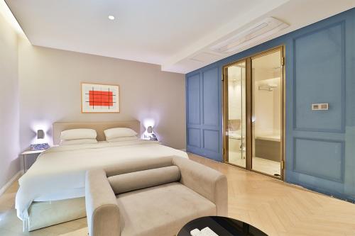 a bedroom with a large bed and a couch at Brown Dot Hotel Ulsan Samsan in Ulsan