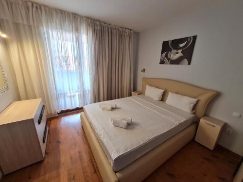 a bedroom with a bed with two towels on it at MitProt ApartCompleks Panorama Bay 2 in Sveti Vlas