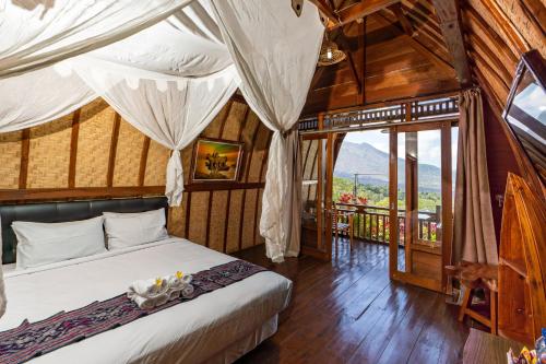 a bedroom with a bed in a room with windows at Tiing Bali Guest House Kintamani in Kintamani