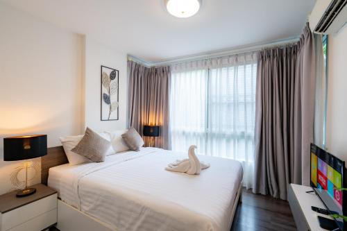 a bedroom with a large white bed with a swan on it at Luxury 2 bedroom Condo Old city 168 in Chiang Mai