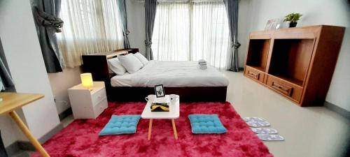 CHIANG MAI Home في شيانغ ماي: غرفة نوم صغيرة بسرير وطاولة وكراسي