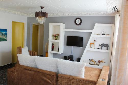 a living room with a couch and a tv at HN airbnb in Nairobi