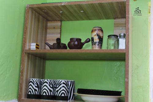a shelf with various items on it in a green wall at HN airbnb in Nairobi