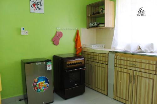 a kitchen with a stove and a green wall at HN airbnb in Nairobi
