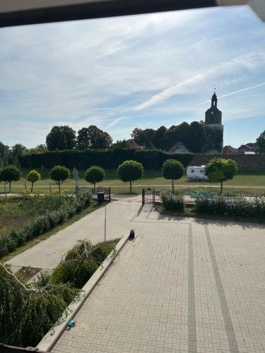 a walkway in a park with a clock tower in the distance at Agroturystyka u Krystyny in Moryń
