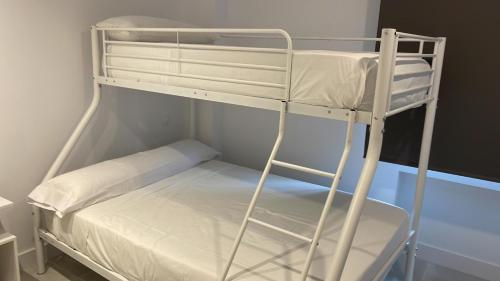 マドリードにあるC7 Exclusiva zona Madridの小さな部屋の白い二段ベッド1台分です。