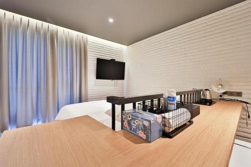 a hotel room with a bed and a table with a television at Brown Dot Hotel Ulsan Samsan in Ulsan