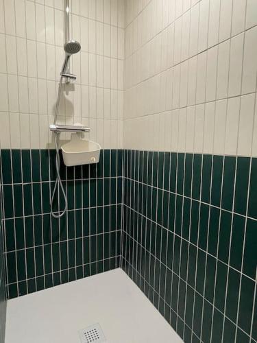 La salle de bains est pourvue de carrelage vert et blanc et d'un lavabo. dans l'établissement Studio - Centre de Villefranche de Lauragais, à Villefranche-de-Lauragais