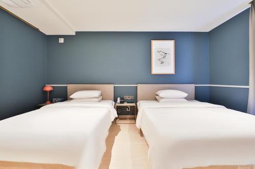 two beds in a room with blue walls at Brown Dot Hotel Ulsan Samsan in Ulsan