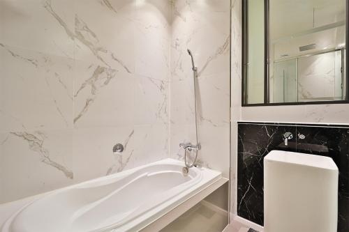 a white bathroom with a tub and a toilet at Brown Dot Hotel Ulsan Samsan in Ulsan