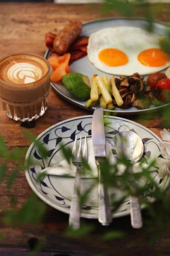 a table topped with plates of food with eggs and meat at 6號花園別墅酒店 Shenzhen No'6 Garden Villa --French Window with garden view,Close to Sea World &Shekou Ferry Port &K11 Ecoast &Subway Nearby ,Offer Western food and coffee &English speaking with tour services in Shenzhen