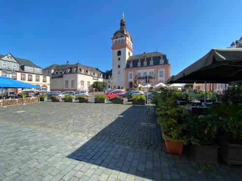 una piazza cittadina con una torre dell'orologio sullo sfondo di Weilburg-Domizil a Weilburg