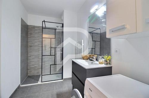 een badkamer met een wastafel en een douche. bij Apparemment T2 en résidence calme fermée in Marseille