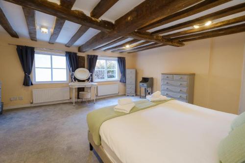 a bedroom with a large white bed and a window at Hill House Apartment in Framlingham