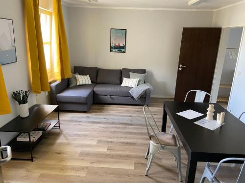 uma sala de estar com um sofá e uma mesa em Bayern Lodge München em Munique