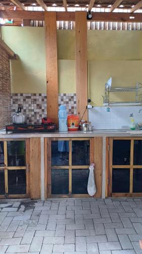 a kitchen with wooden cabinets and a counter top at Omah Kepel Yogyakarta in Soprayan