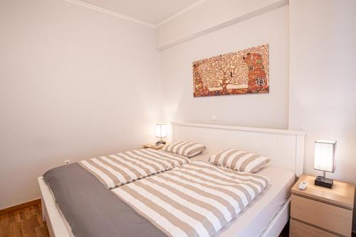 - une chambre blanche avec un lit et deux oreillers dans l'établissement Hermes Apartments, 2 bedrooms, great facilities!, à Athènes