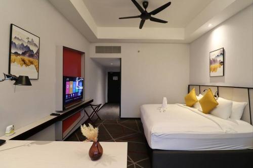 um quarto de hotel com uma cama e uma televisão de ecrã plano em M101 KLCC KL city King Suites by Livin em Kuala Lumpur