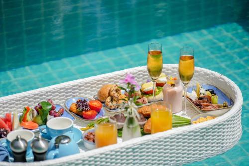 a tray of food and drinks next to a swimming pool at Ifuru Island Maldives - FREE Return Domestic Flight for 2 with a minimum 5-night stay until Nov 2025 in Raa Atoll