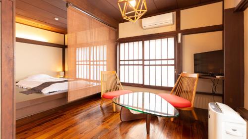 1 dormitorio con 1 cama, mesa y sillas en Ryokan Hiyoshi, en Chichibu