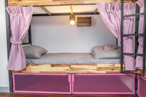 um beliche num quarto com uma cama cor-de-rosa em K-Bunk Hostel Pai Walking Street em Pai