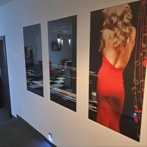 a wall with three pictures of a woman in a red dress at Piano in Nowy Sącz