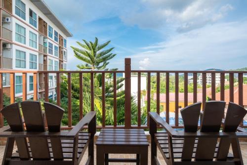a patio with two chairs and a table on a balcony at Orchid Pool Villa Phuket - SHA Extra Plus in Phuket Town