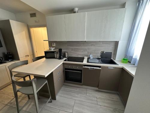 Una cocina con fregadero y una mesa con sillas. en Appartamento Campagnola 10, en Riva del Garda