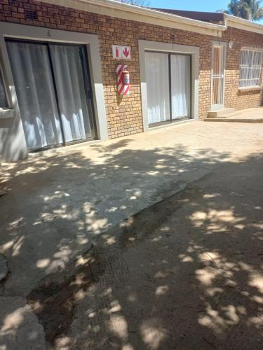 a parking lot in front of a brick building at Rocky Hills Guesthouse in Piet Retief