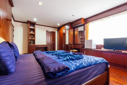 a bedroom with a large bed and a flat screen tv at Orchid Pool Villa Phuket - SHA Extra Plus in Phuket Town