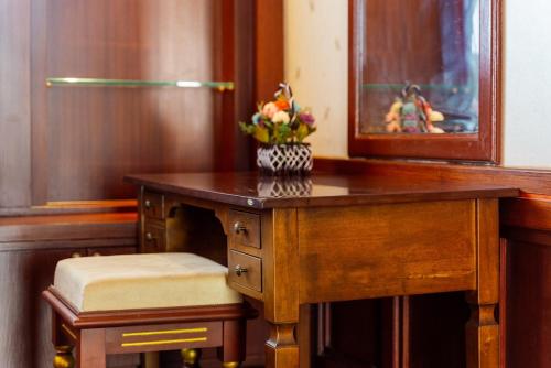 a wooden desk with a vase of flowers on it at Orchid Pool Villa Phuket - SHA Extra Plus in Phuket Town