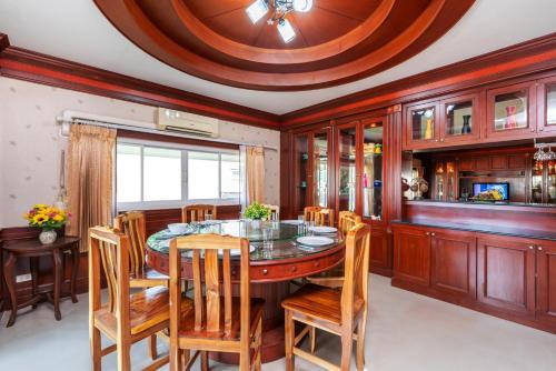 a dining room with a circular table and chairs at Orchid Pool Villa Phuket - SHA Extra Plus in Phuket Town