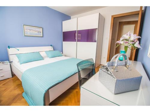 a blue bedroom with a bed and a glass table at Apartment Seagull in Split