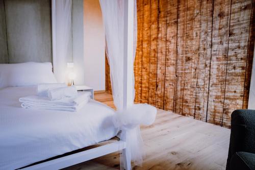 a bedroom with a bed with white sheets and a window at Villa Pellegrini in Grezzana