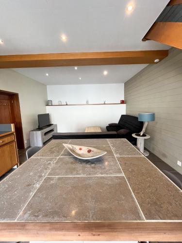 uma cozinha e sala de estar com uma mesa e um sofá em la petite maisonnette em Le Plessis-Feu-Aussoux