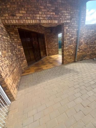 an empty room with a brick wall at Rocky Hills Guesthouse in Piet Retief
