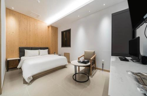 a bedroom with a white bed and a television at HOTEL MYEONG JAK in Suwon