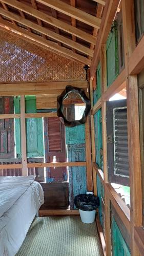 a bedroom with a bed in a wooden cabin at Omah Kepel Yogyakarta in Soprayan