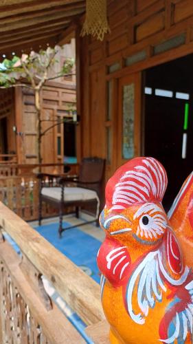 a colorful statue of a chicken sitting on a railing at Omah Kepel Yogyakarta in Soprayan