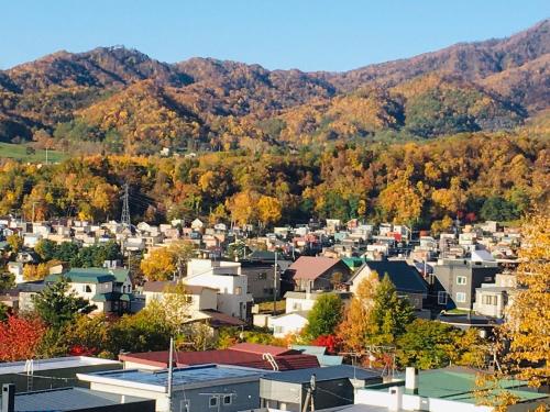 uma cidade no outono com montanhas no fundo em 民泊森の家 em Moiwashita