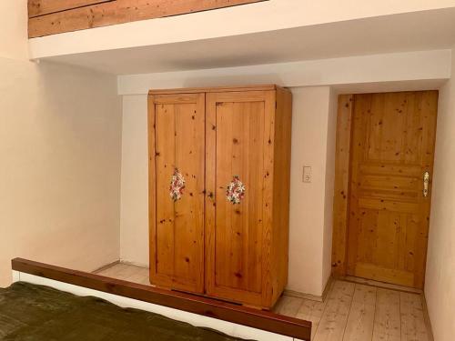 1 dormitorio con armario de madera y puerta en Sweet Mountain Home, en Bad Bleiberg