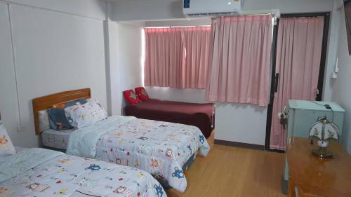a small bedroom with two beds and a window at Victory view rayong beach in Ban Chamrung